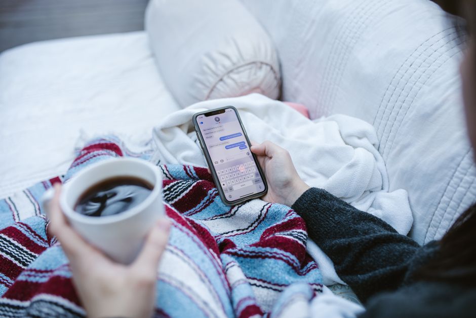 Persona relajada usando smartphone en un entorno acogedor