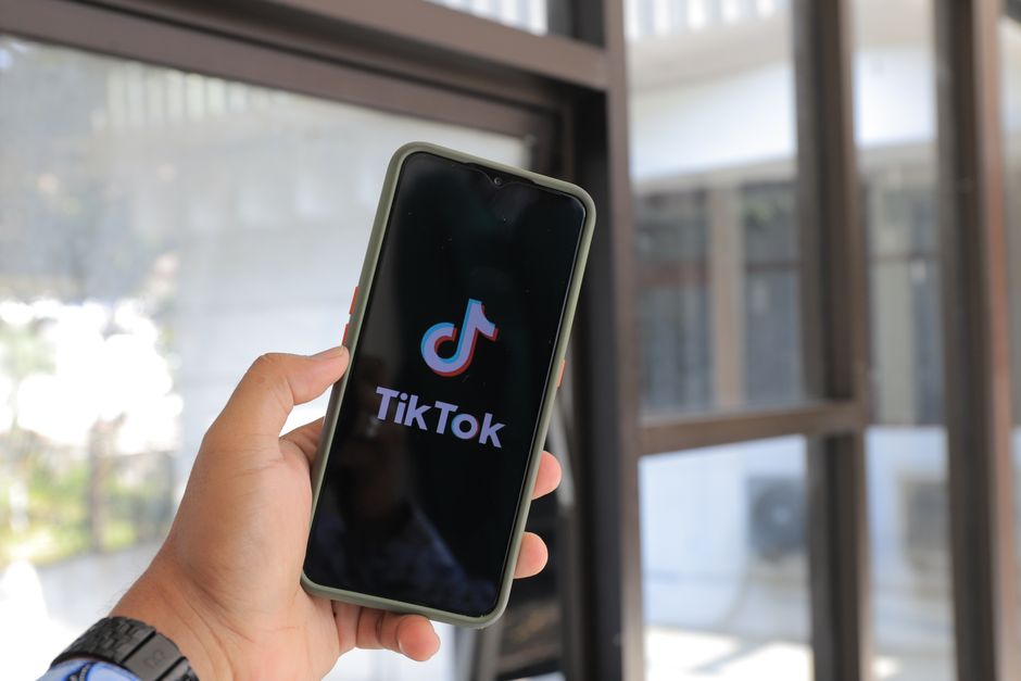 Mano sosteniendo smartphone con app TikTok